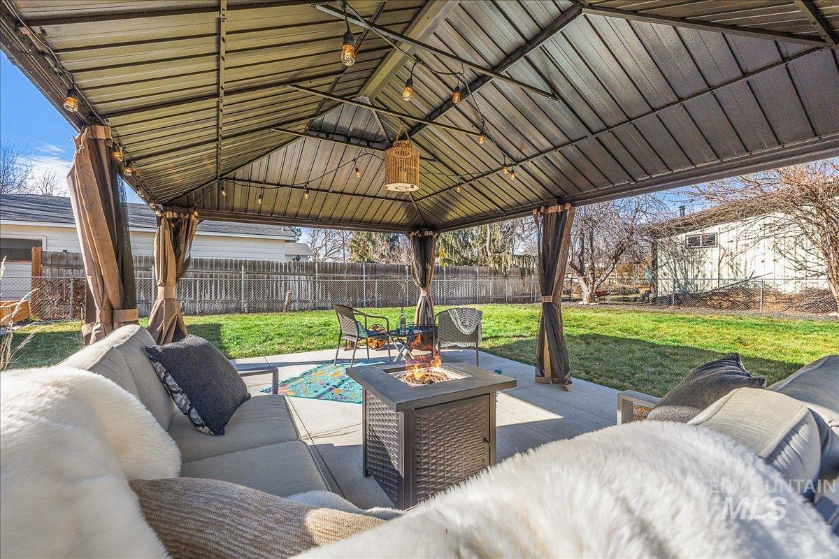 Fenced backyard with a patio area and an outdoor living space with a fire pit