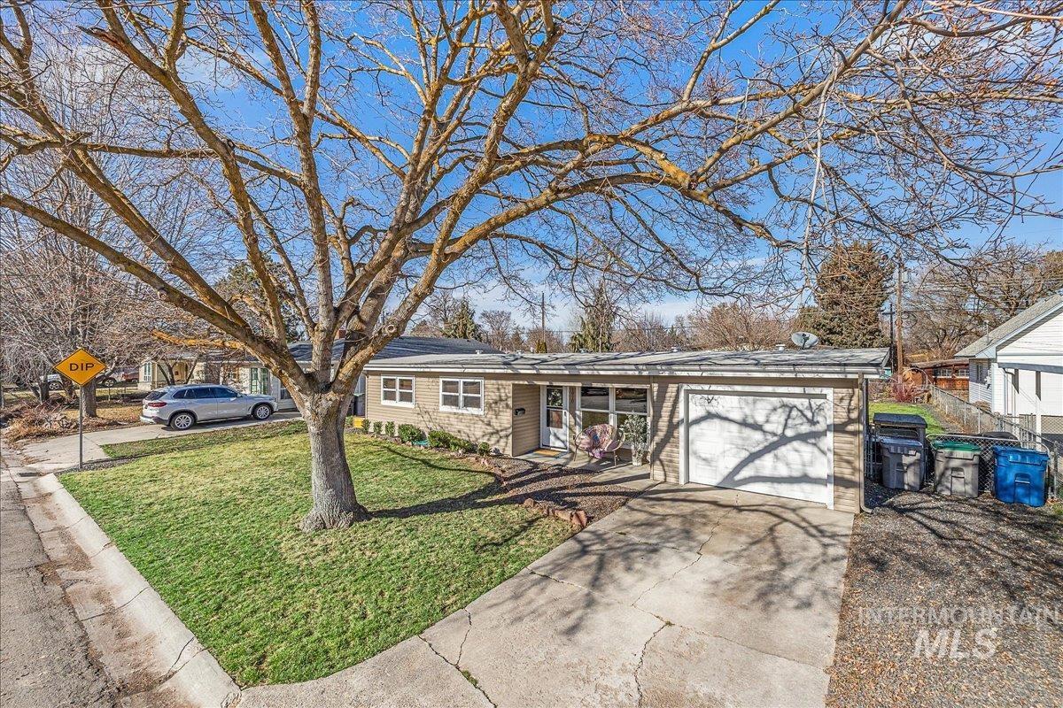 Ranch-style house with a garage, driveway, and a front yard