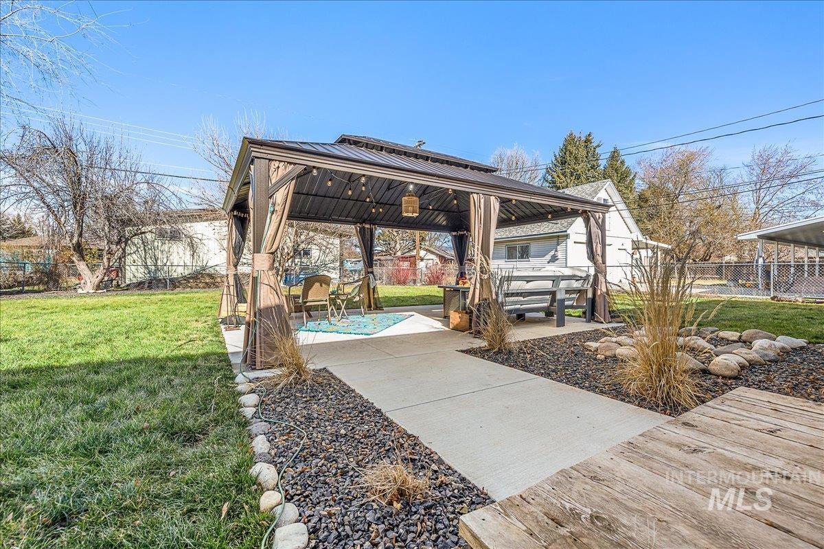 Fenced backyard featuring a gazebo and a patio area