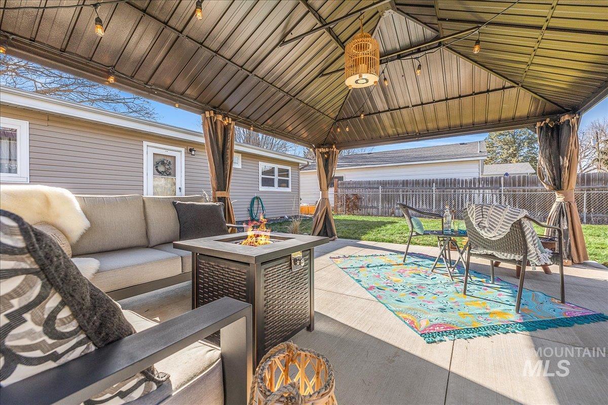 View of patio / terrace featuring an outdoor living space with a fire pit and a gazebo