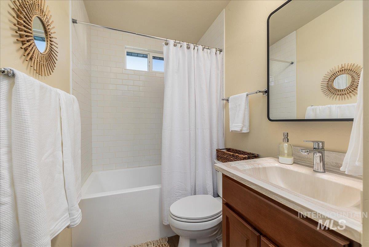 Full bathroom featuring shower / tub combo with curtain and vanity