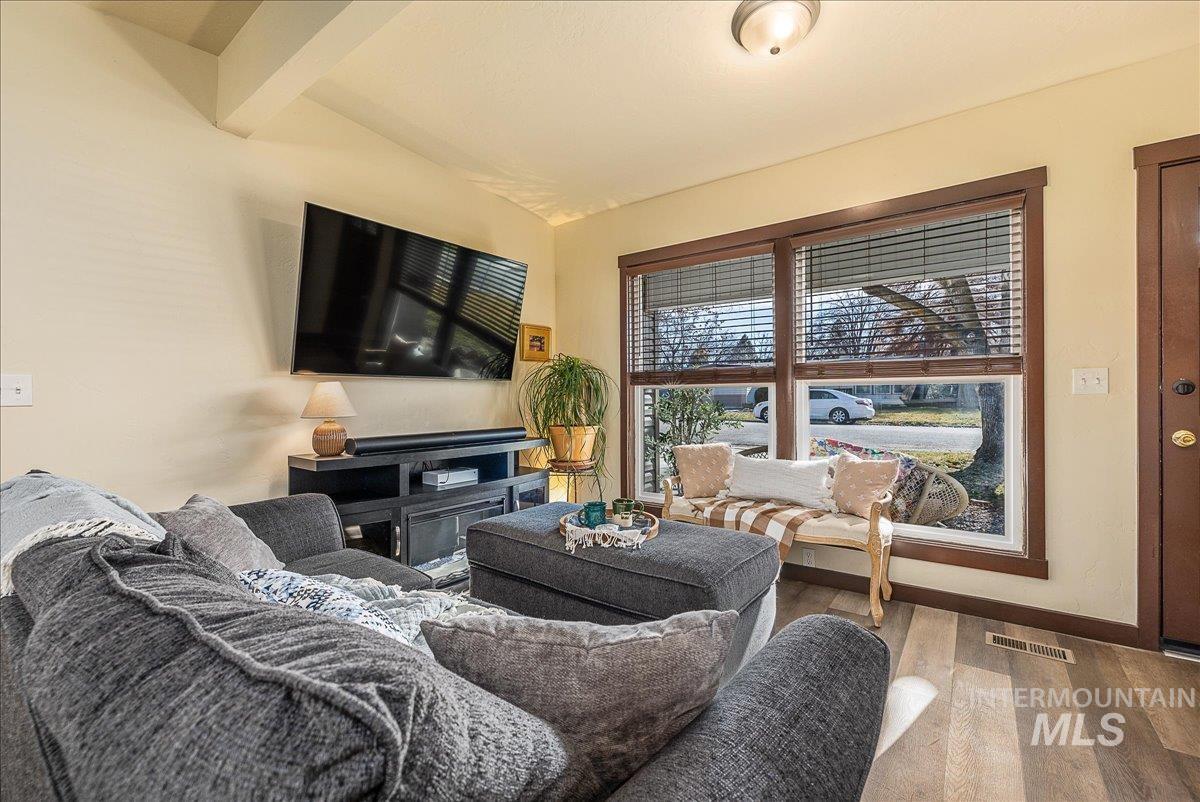 Living room featuring lofted ceiling with beams and wood finished floors