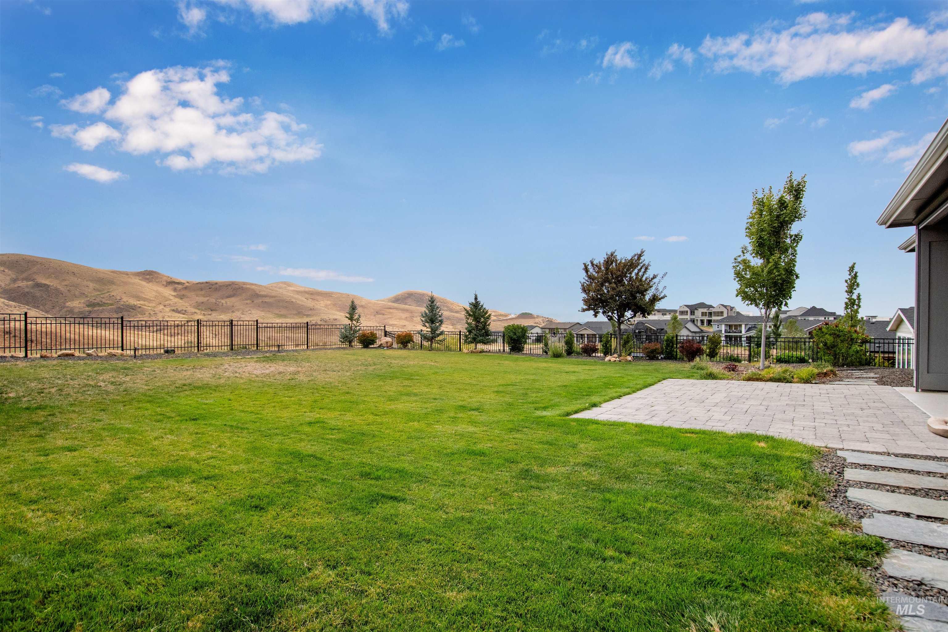 Fenced backyard with a patio, a mountain view, and a view of countryside