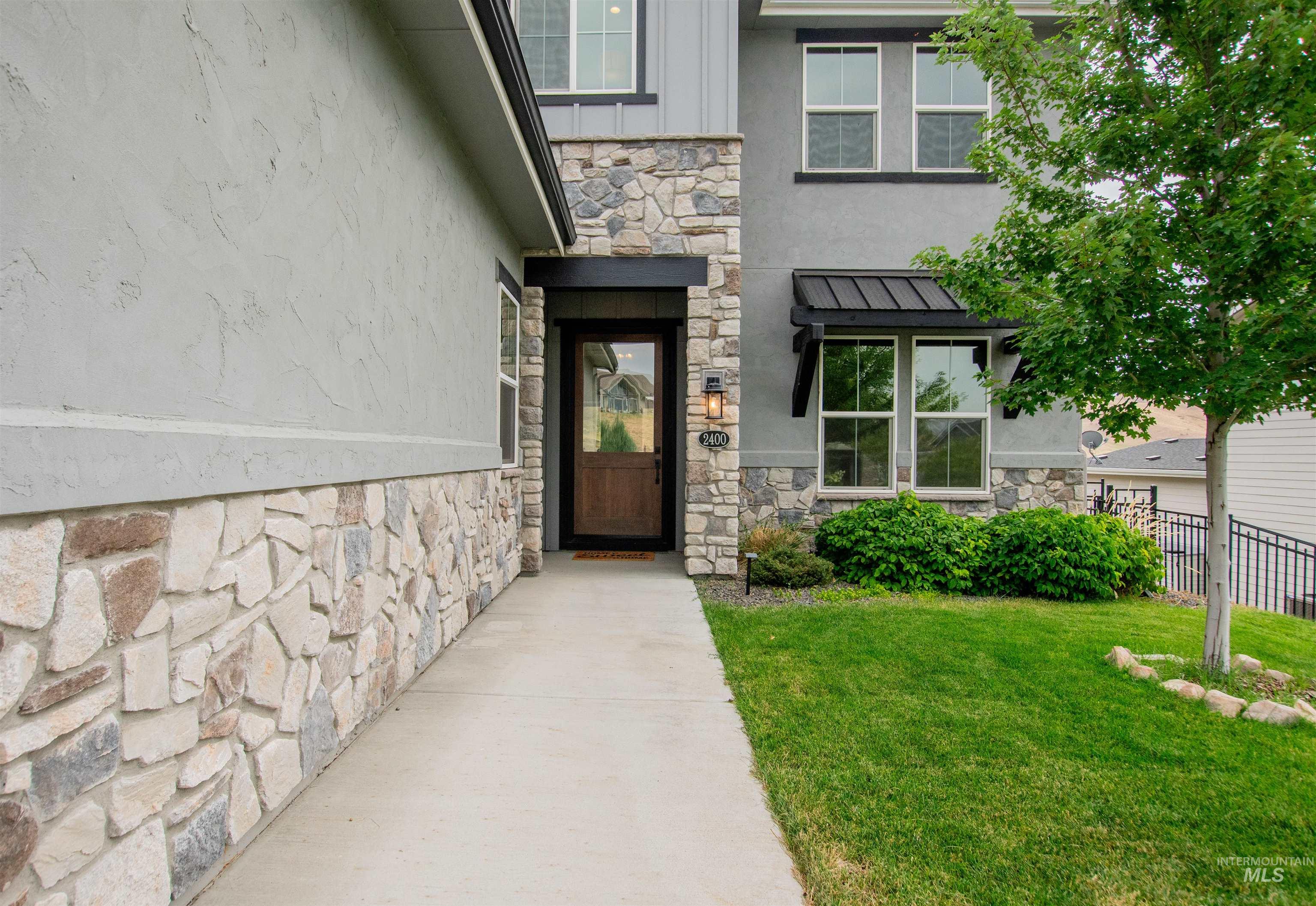 Property entrance featuring stone siding and stucco siding