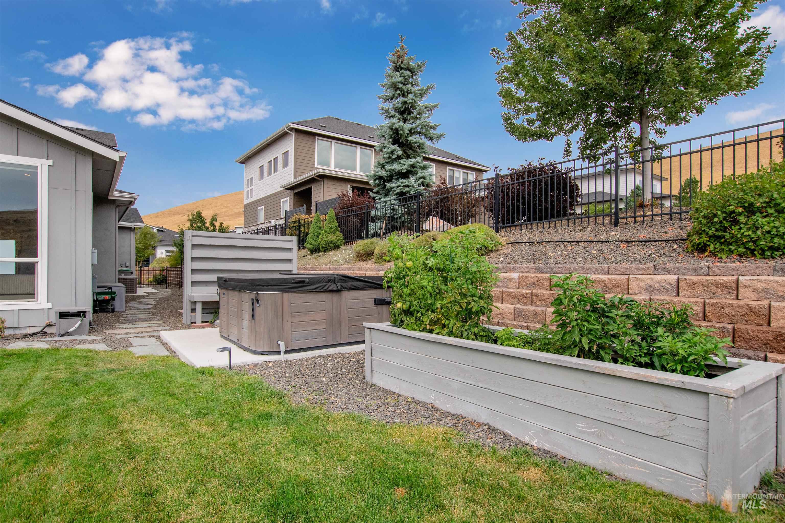 View of yard featuring a patio area, a hot tub, and a garden