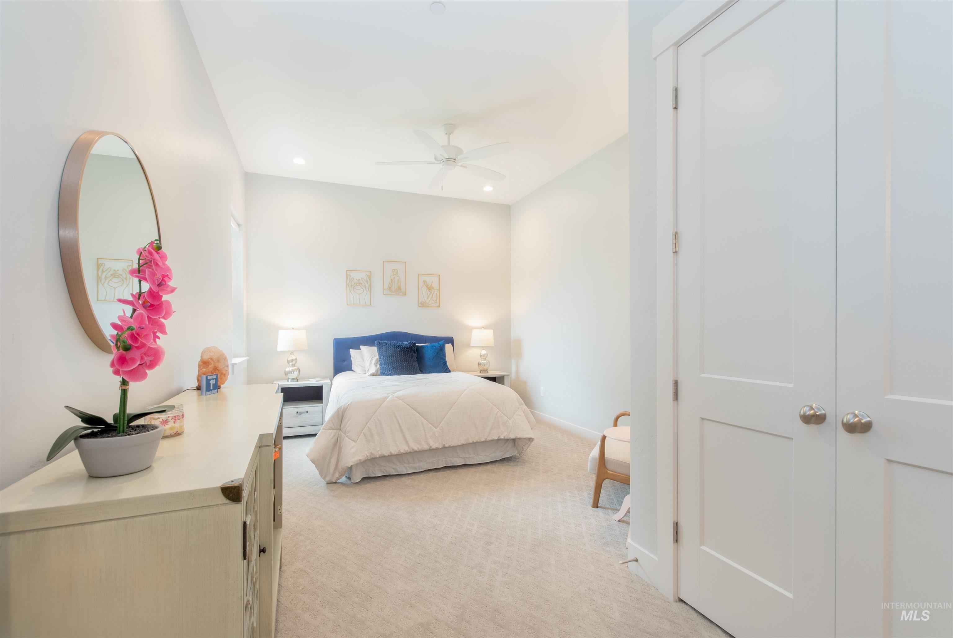 Bedroom with light colored carpet, recessed lighting, and a ceiling fan