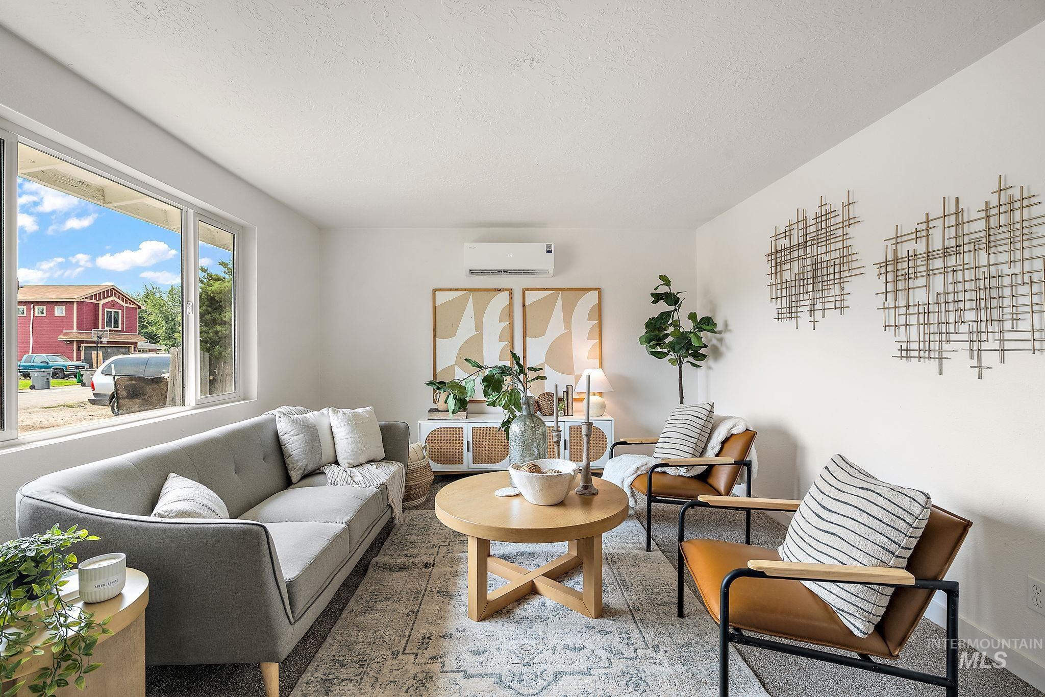 Living room featuring a textured ceiling and a wall mounted air conditioner