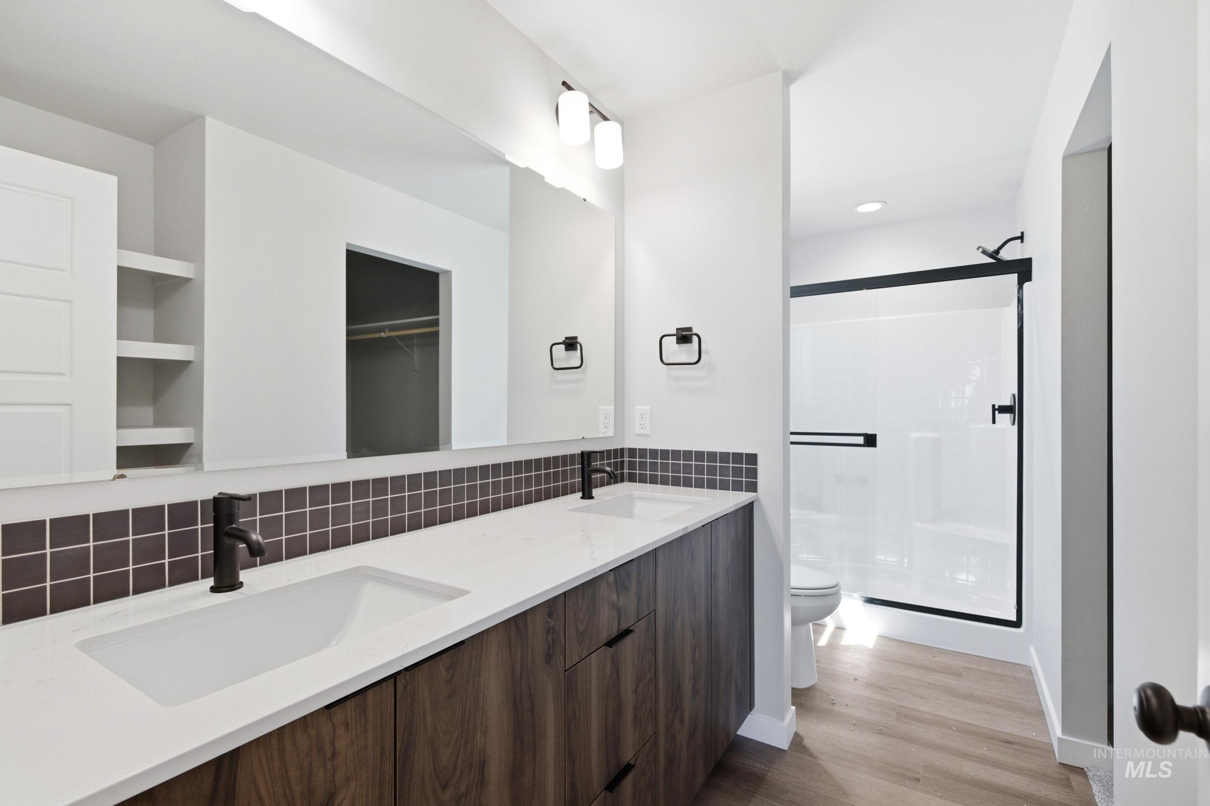 Dual vanity with integrated rectangular sinks, wood-finish cabinetry, and matte black fixtures