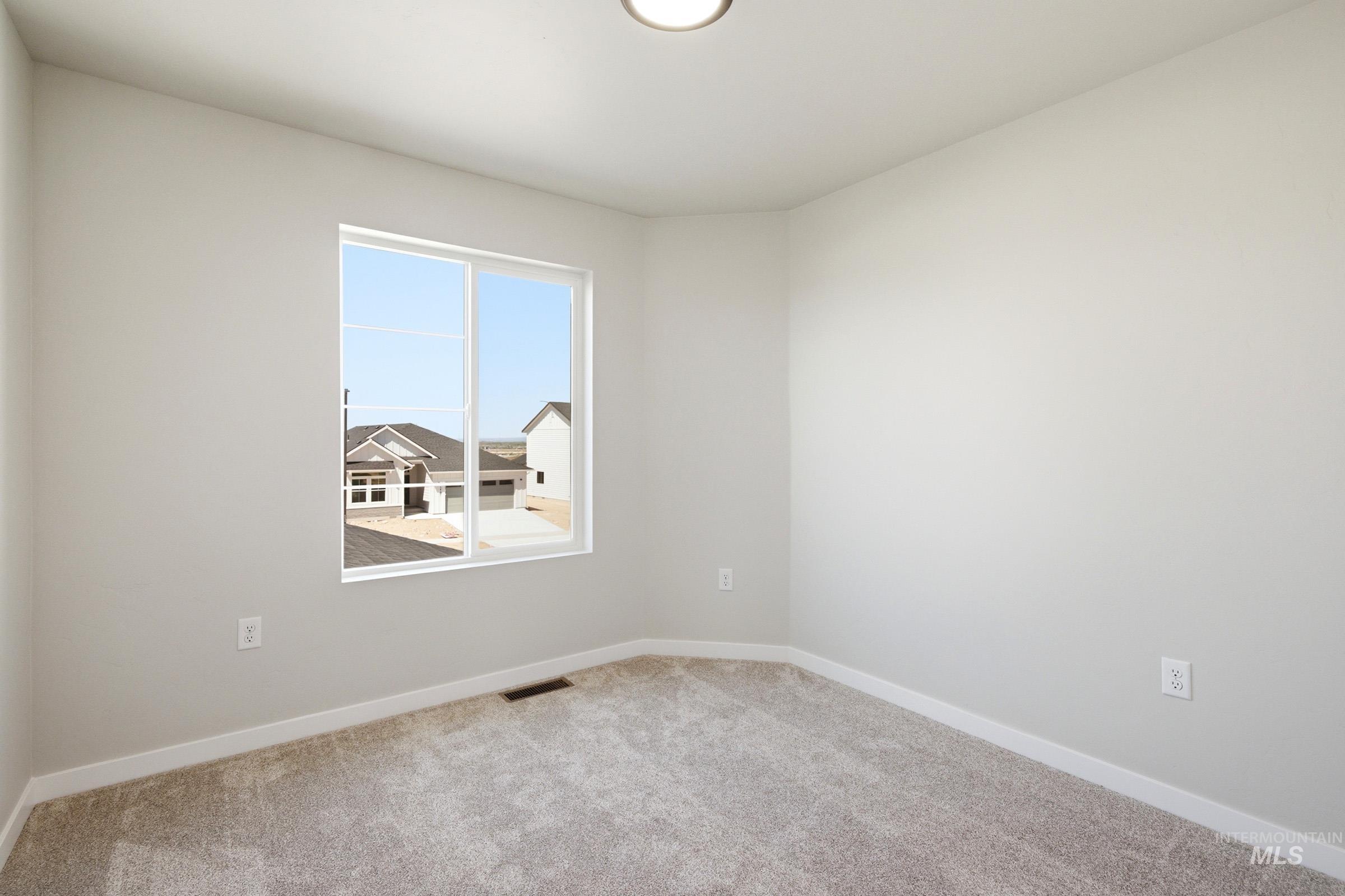 Carpeted room featuring a double-pane window, white baseboards, and a flush-mount ceiling light fixture