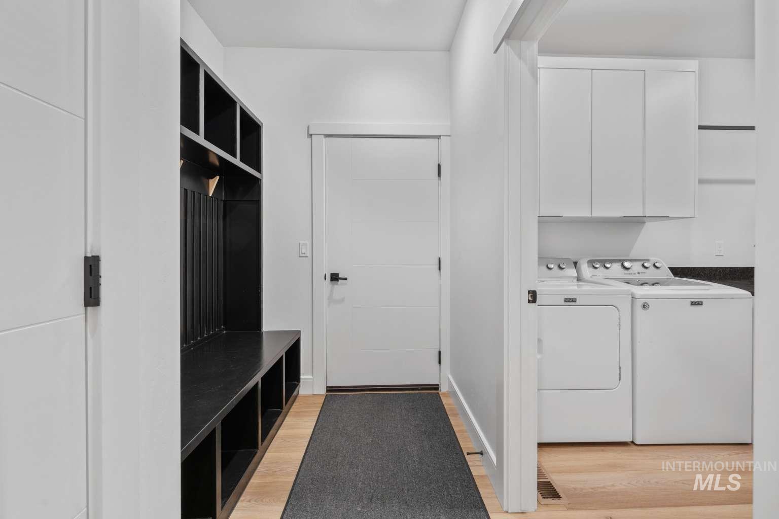 Mudroom featuring light wood-style flooring and washing machine and dryer