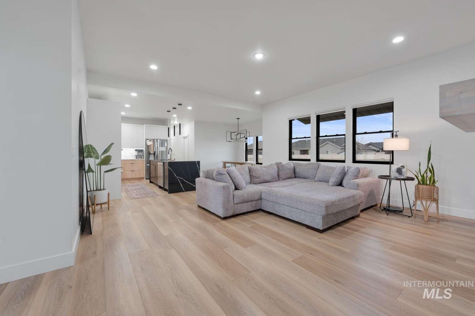 Living area featuring light wood-style flooring and a chandelier