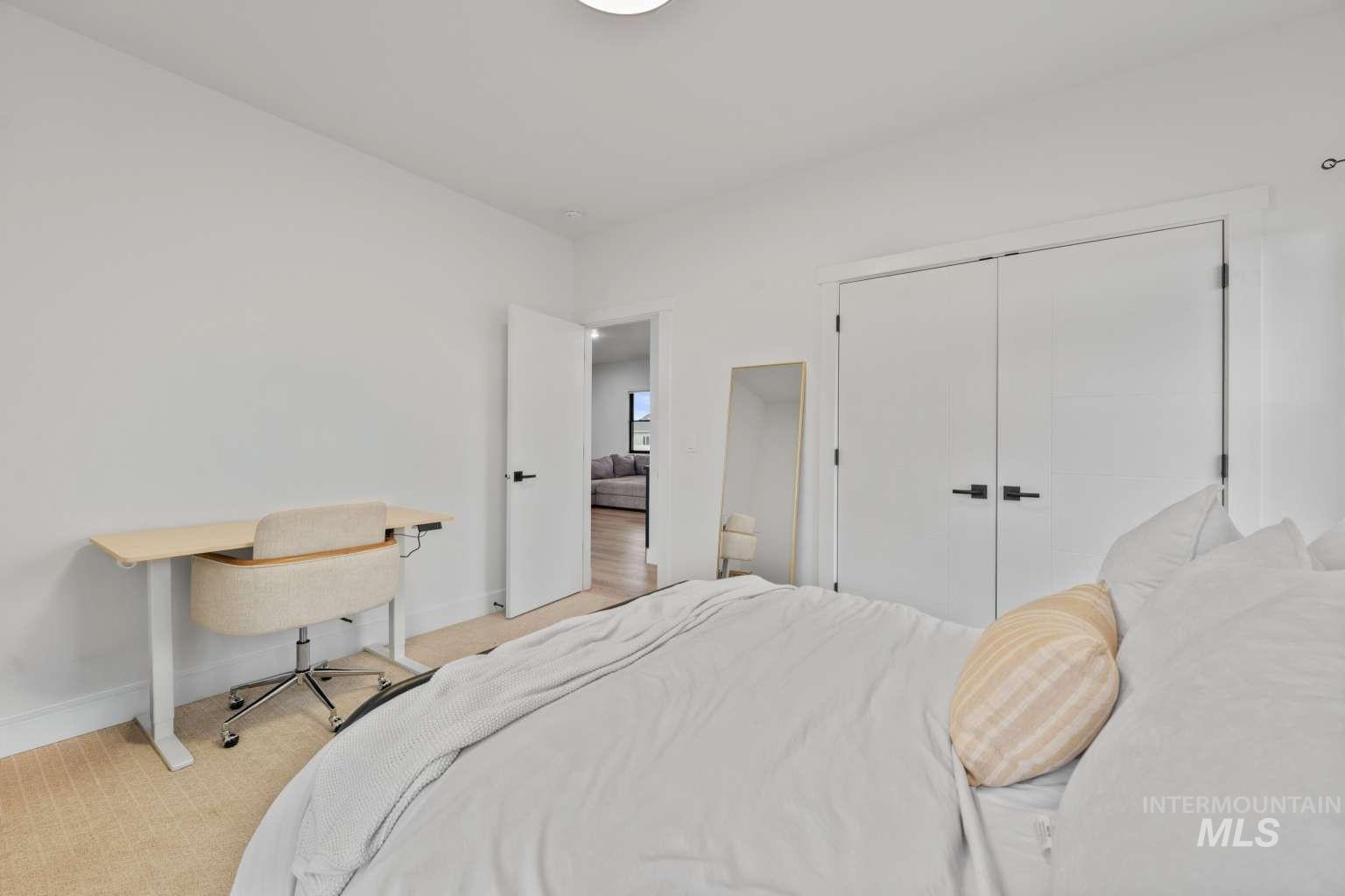 Bedroom with carpet, a closet, and an office area