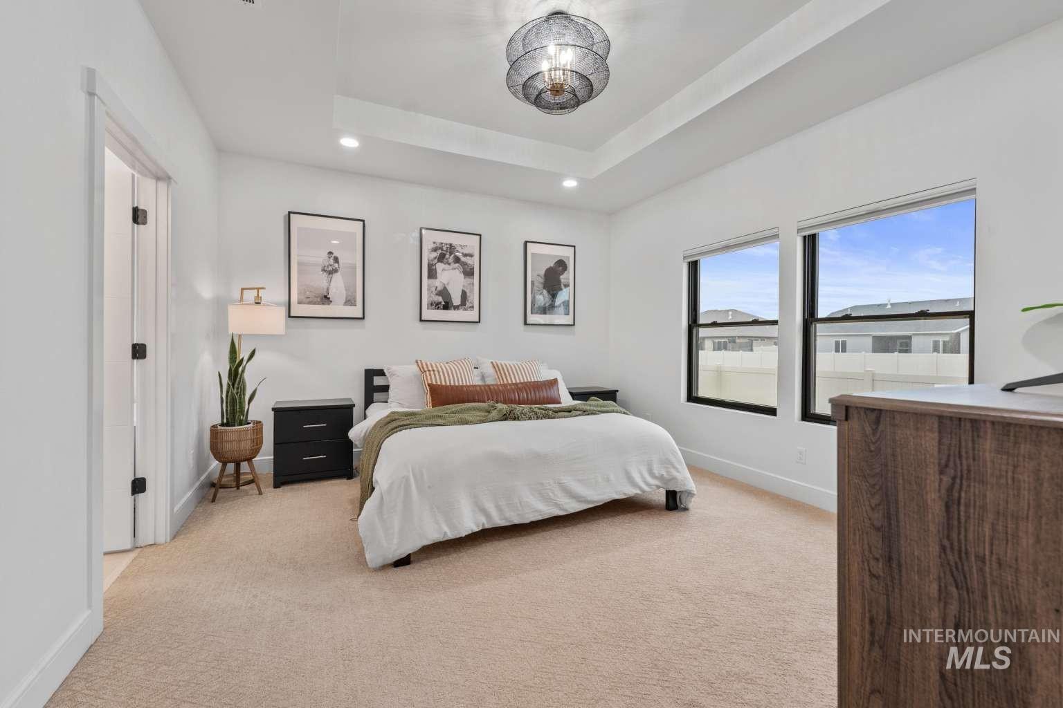 Bedroom featuring light colored carpet and suspended lighting