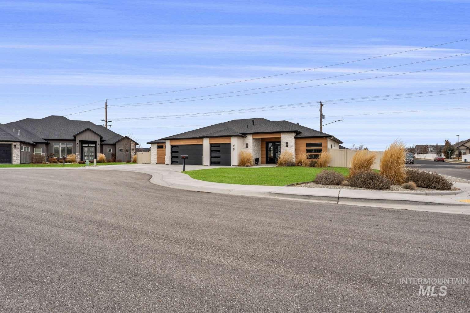 View of front of house with driveway, brick siding, and an attached garage