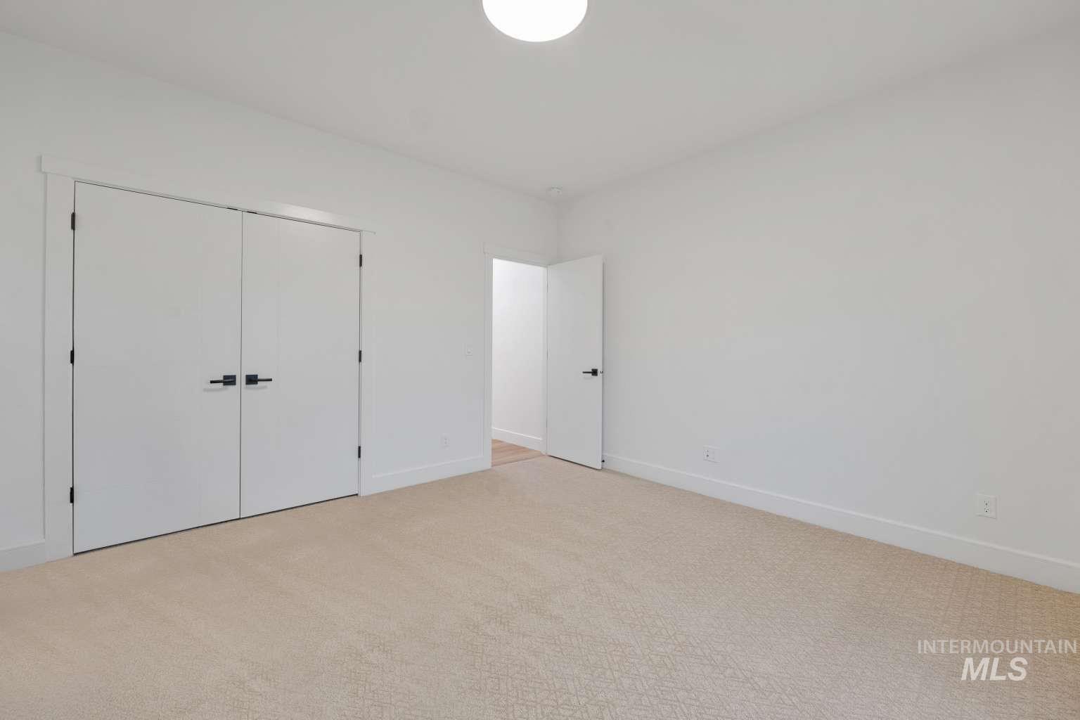 Unfurnished bedroom with light carpet and a closet