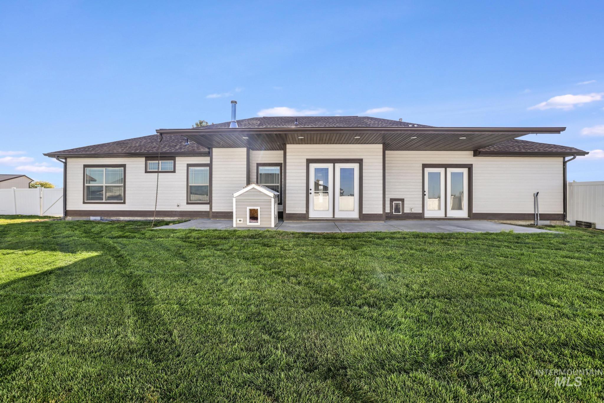 Back of property with a patio, roof with shingles, and french doors