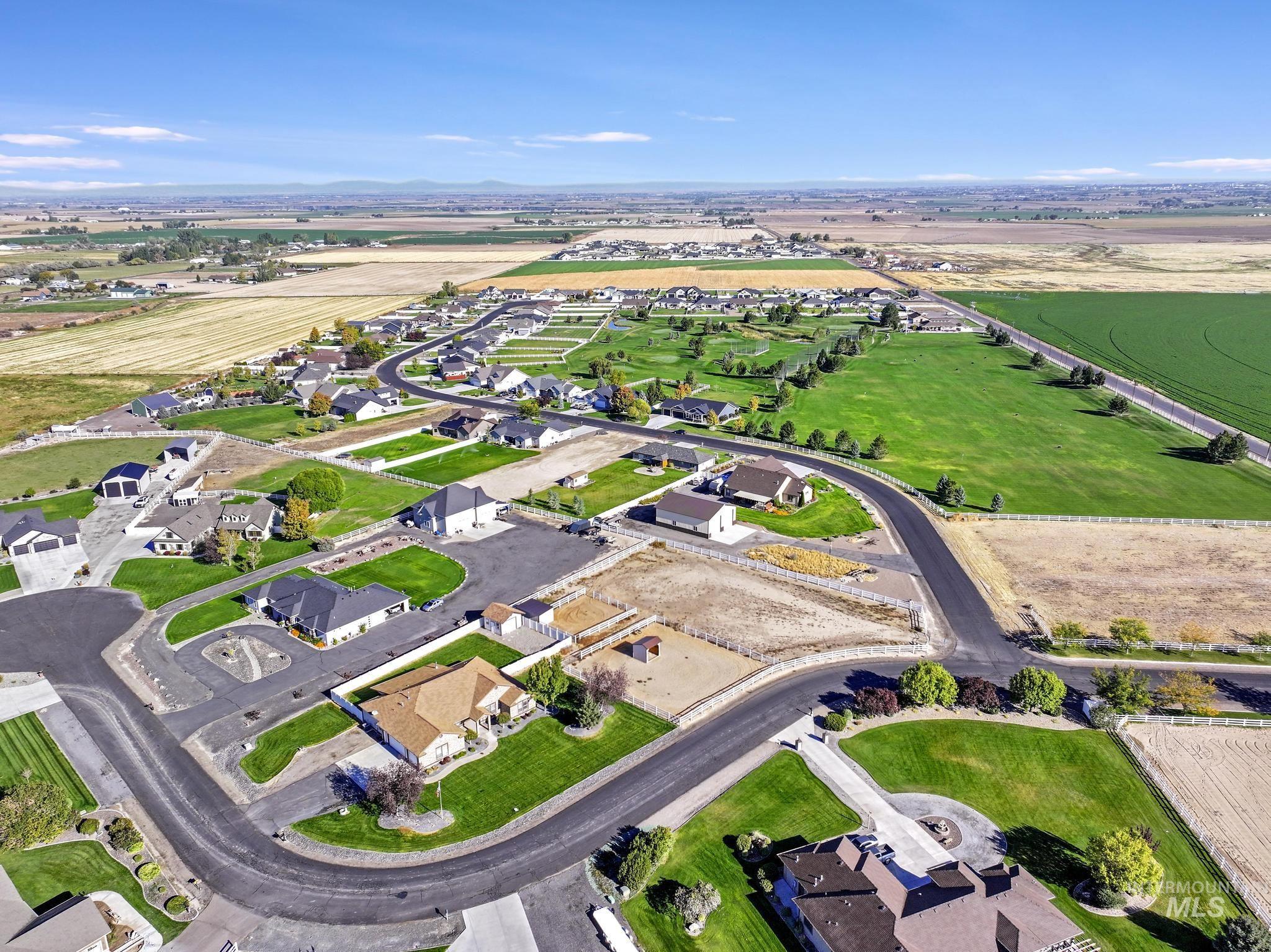 Aerial view of property and surrounding area featuring nearby suburban area and rural landscape