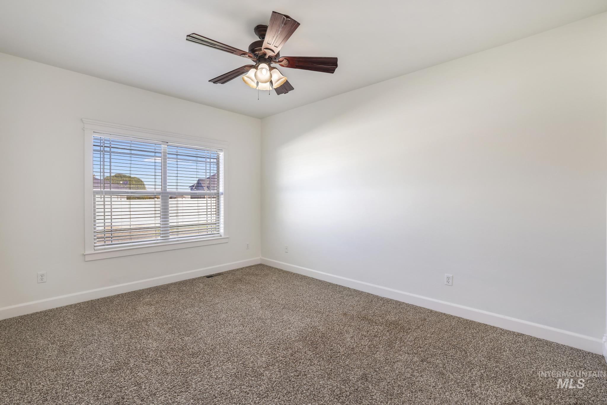 Unfurnished room featuring carpet and a ceiling fan