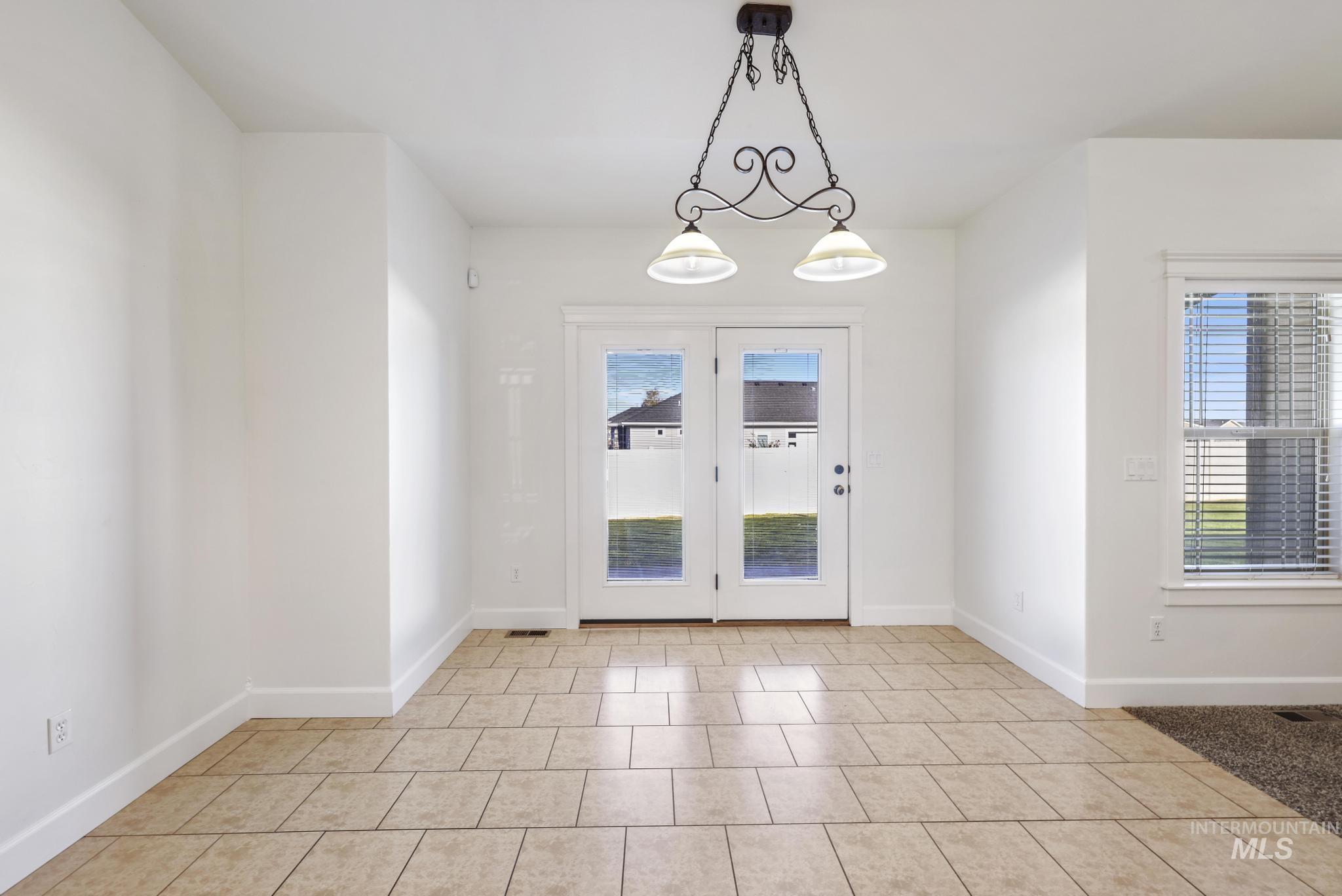 Doorway to outside featuring baseboards and tile patterned flooring