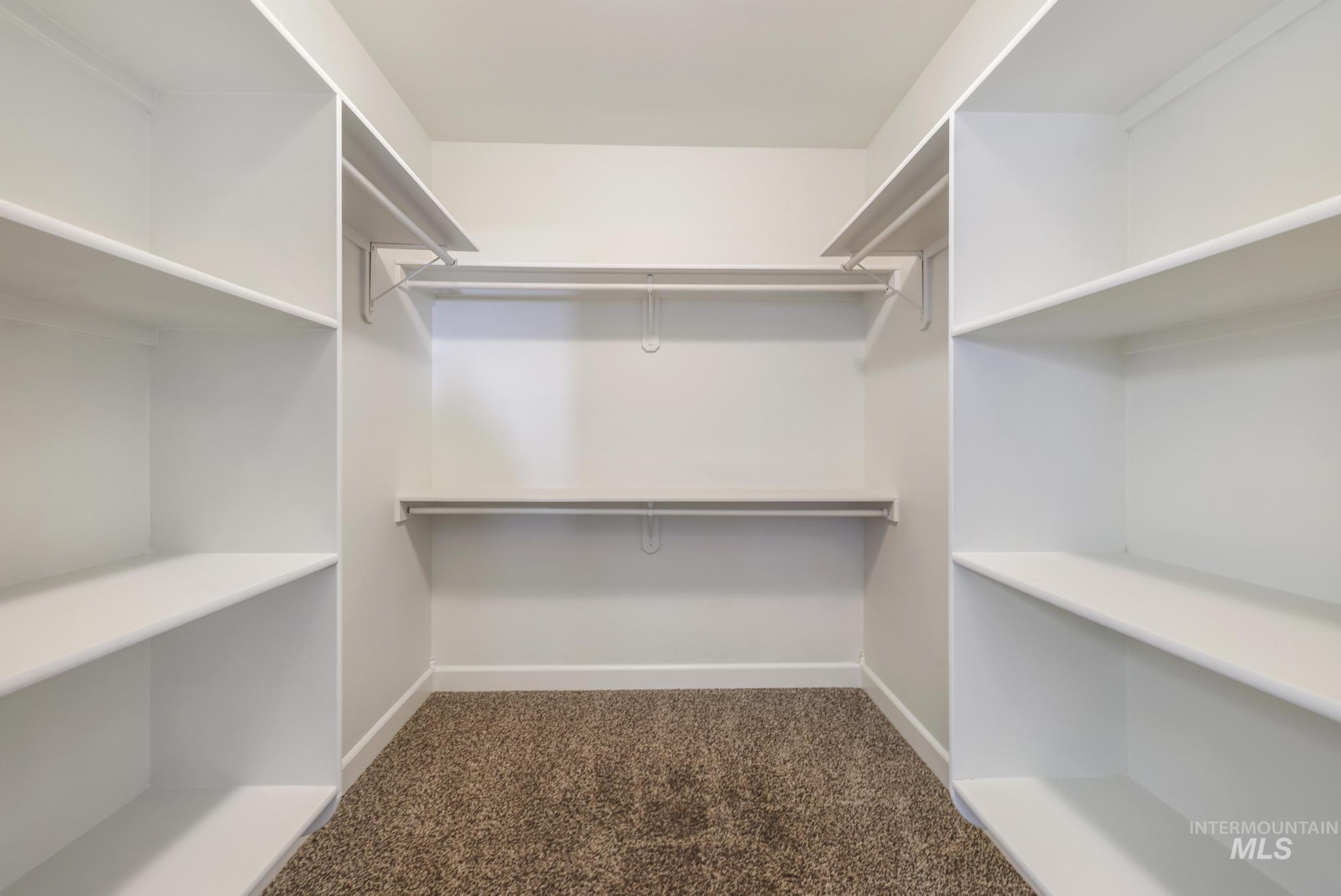 Walk in closet featuring dark carpet