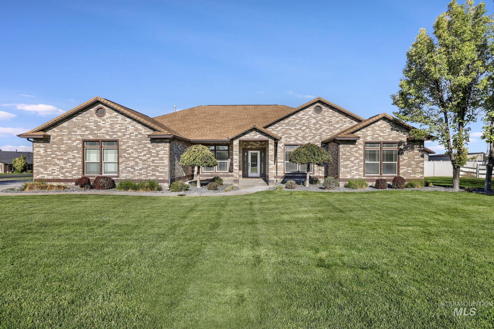 View of front facade featuring a front yard and brick siding