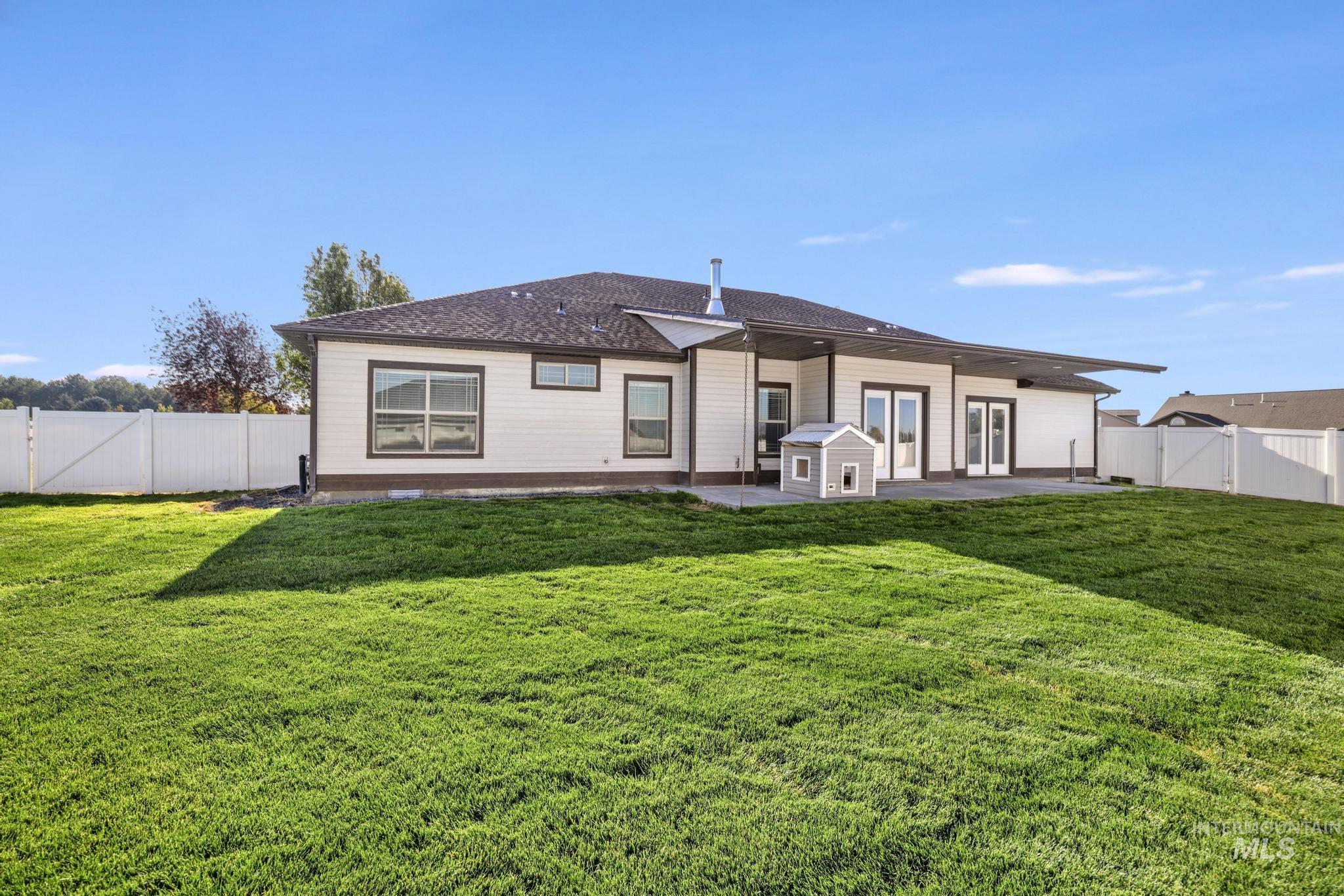 Rear view of property with a fenced backyard and a patio