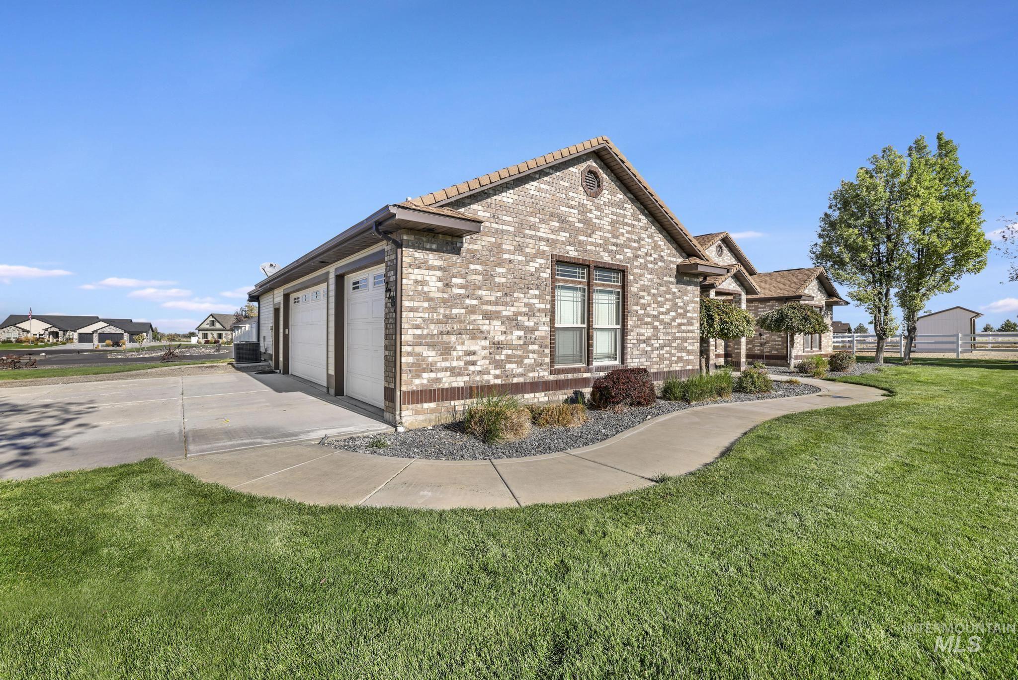 View of side of property with brick siding, driveway, and a garage
