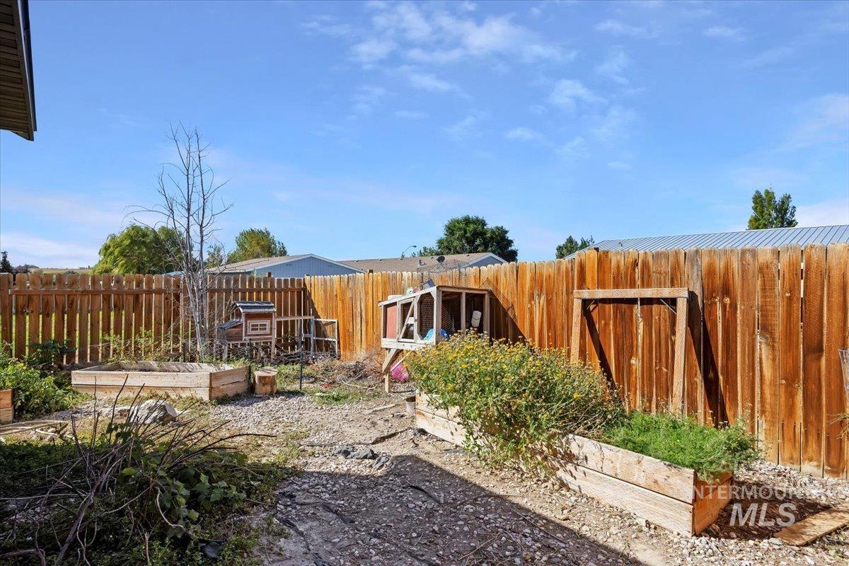 Fenced backyard featuring a garden