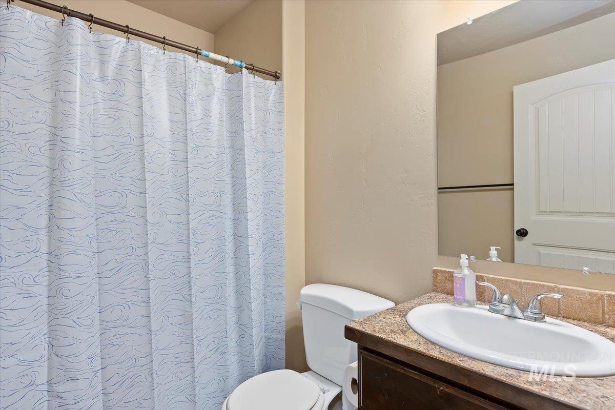 Bathroom with vanity, curtained shower, and a textured wall