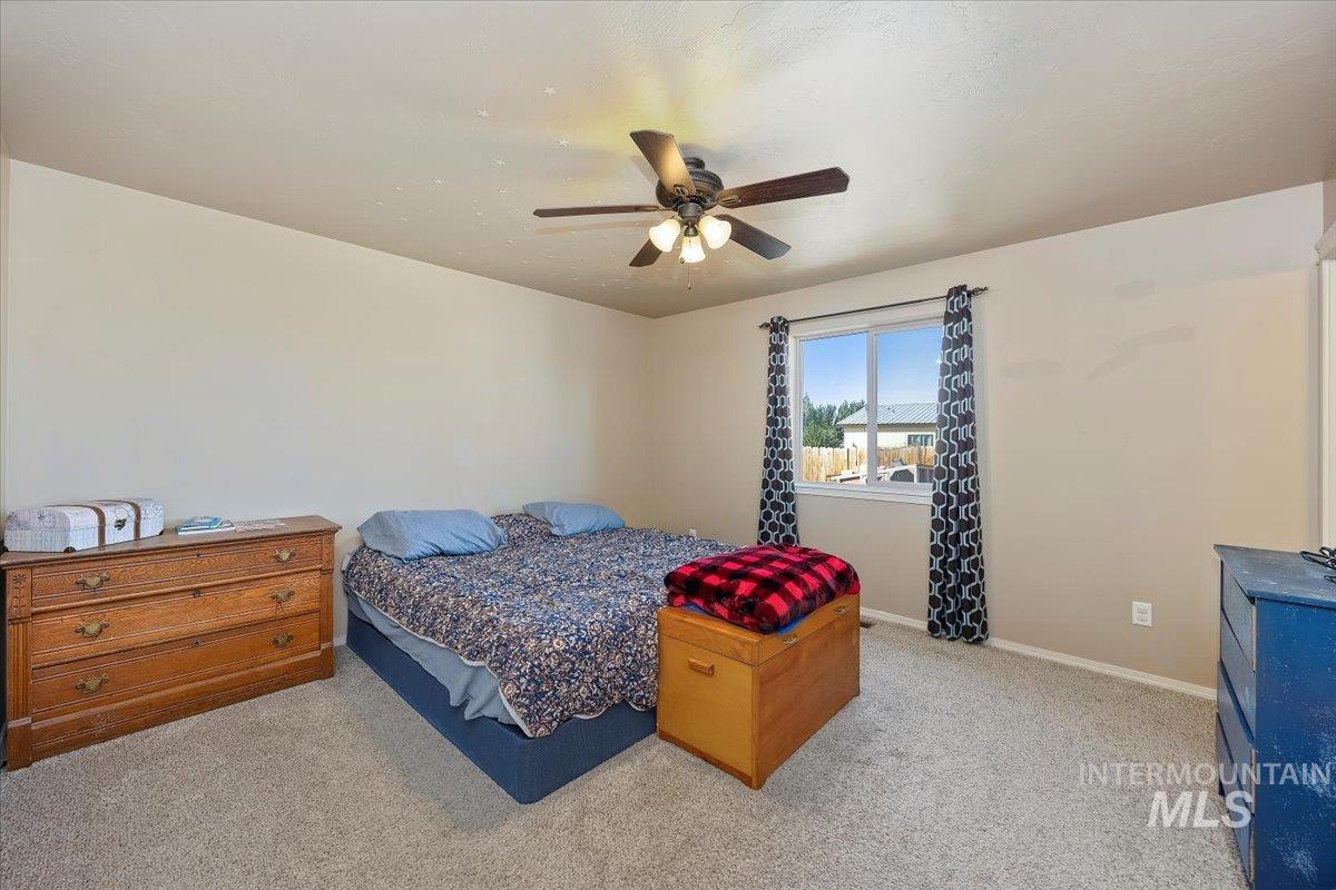 Bedroom with light carpet and a ceiling fan