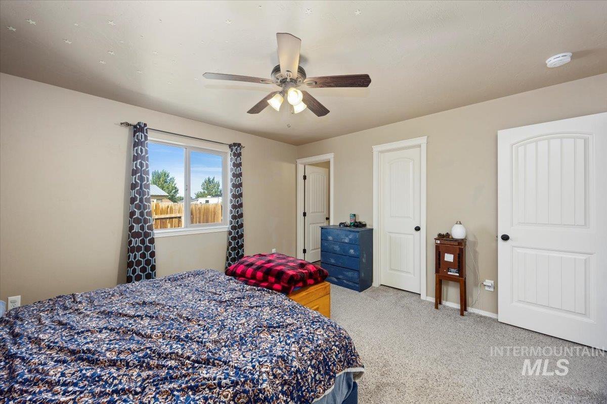 Bedroom featuring light colored carpet and ceiling fan