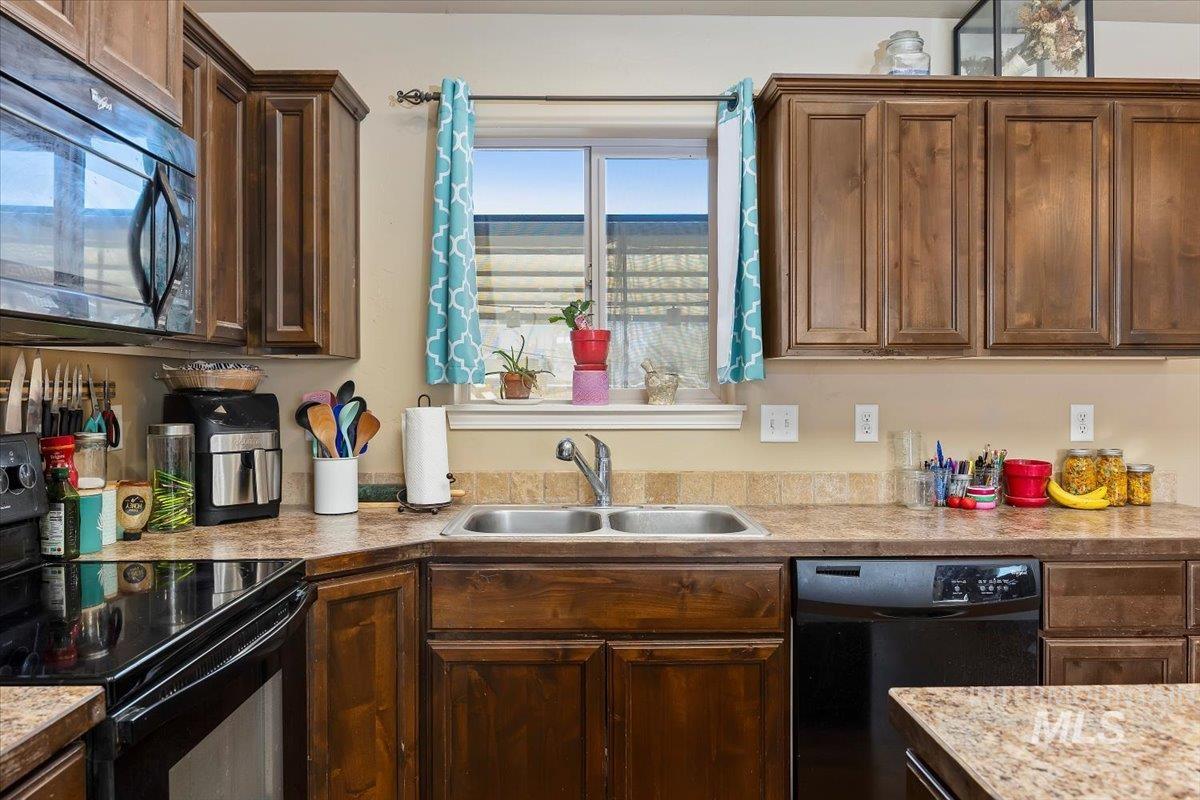 Kitchen featuring black appliances and light countertops