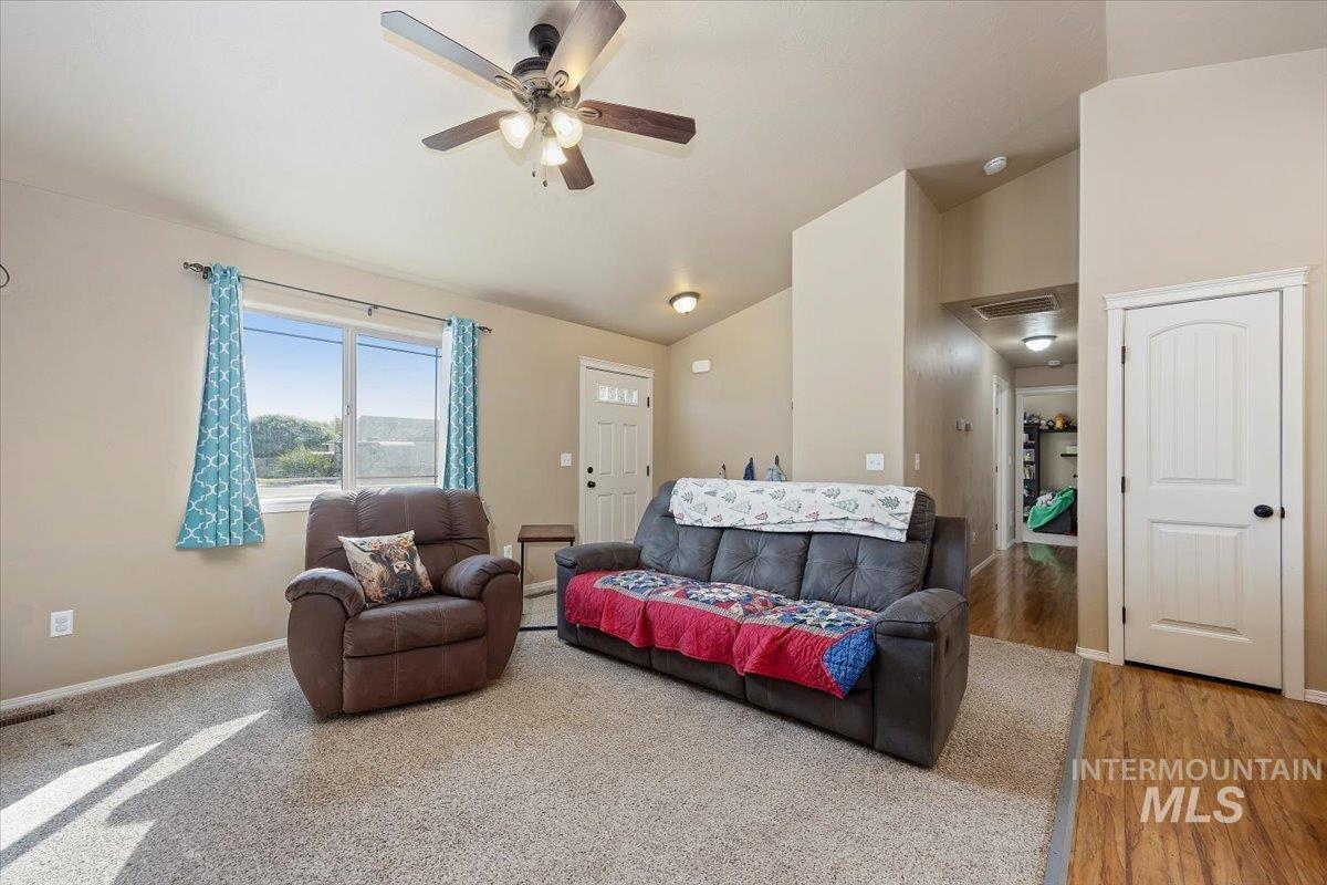 Living area featuring lofted ceiling and a ceiling fan