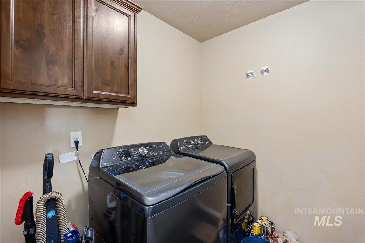 Washroom with cabinet space and washing machine and dryer