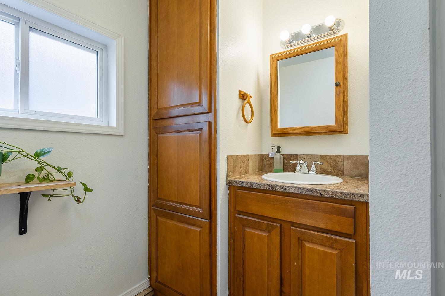 Bathroom with a textured wall and vanity