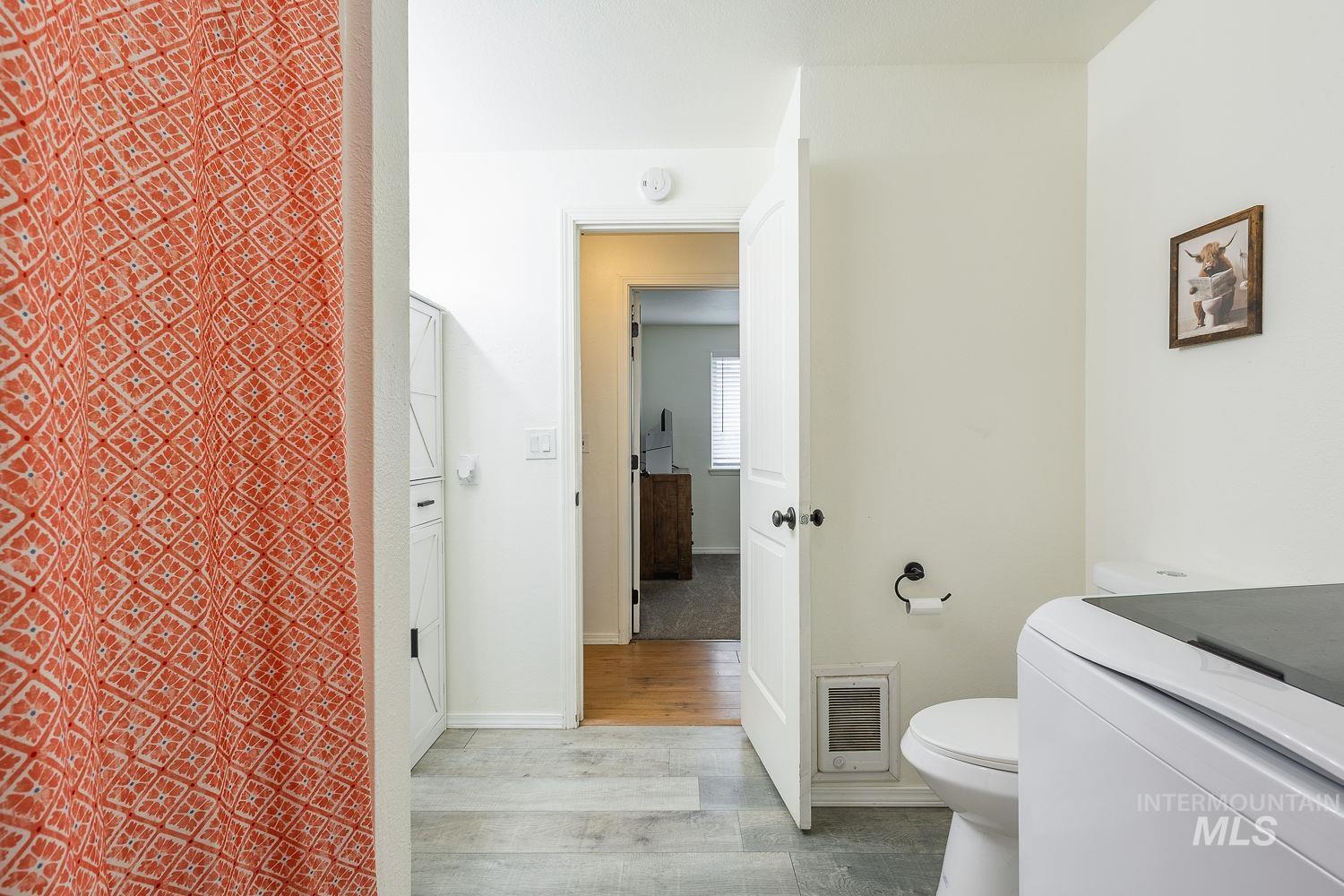 Bathroom featuring light wood-style floors, vanity, and washer / dryer