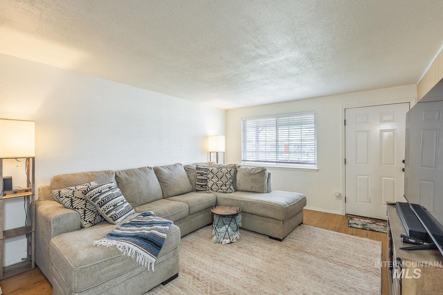 Living room featuring a textured ceiling and wood finished floors
