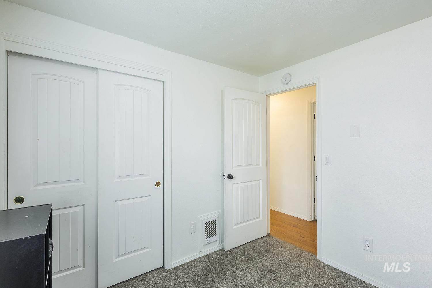 Unfurnished bedroom featuring dark colored carpet and a closet