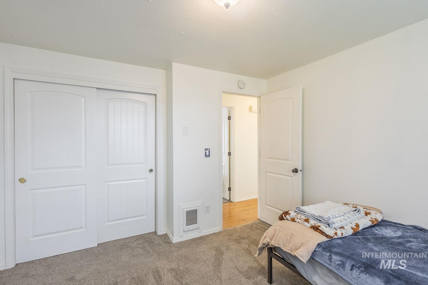 Bedroom featuring light carpet and a closet