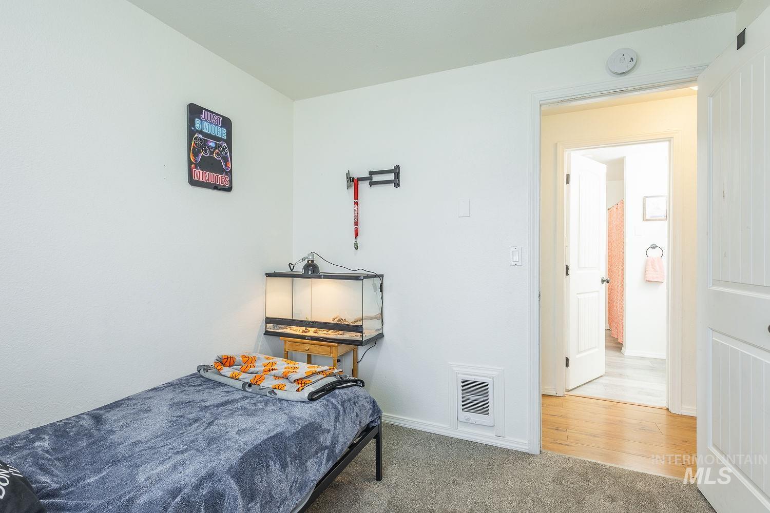 Bedroom featuring light colored carpet and baseboards
