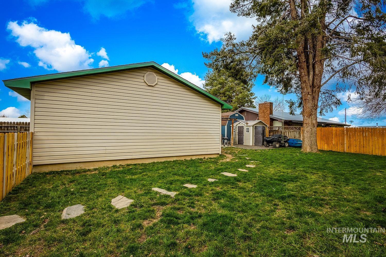 View of side of home with a shed and a fenced backyard