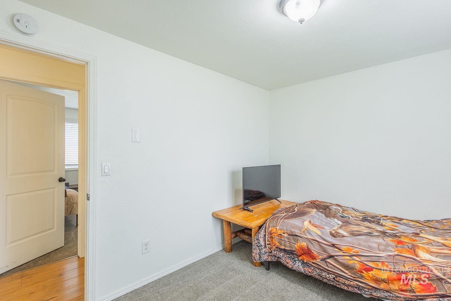 Bedroom featuring light colored carpet and baseboards