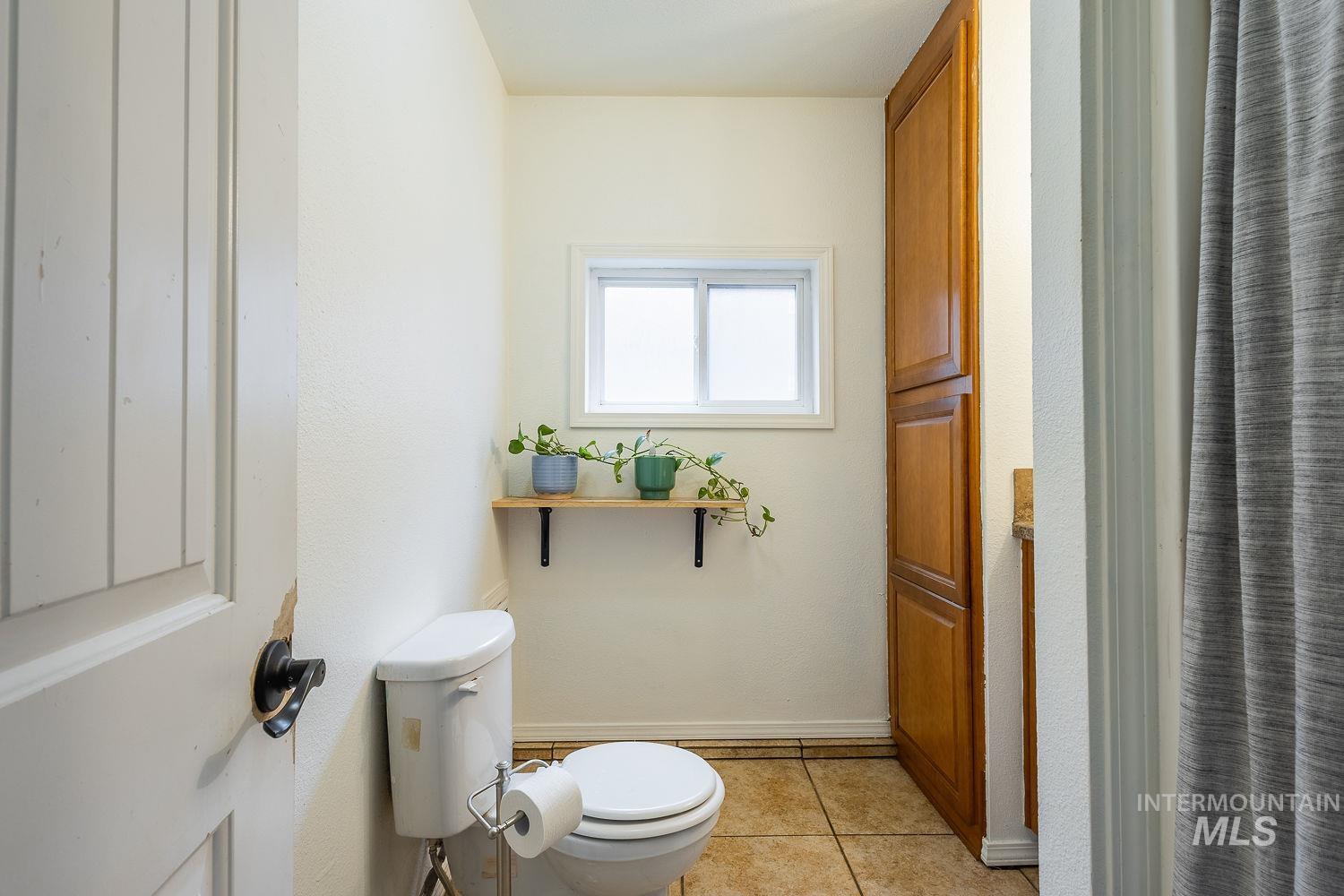 Bathroom featuring light tile patterned flooring and a shower with shower curtain