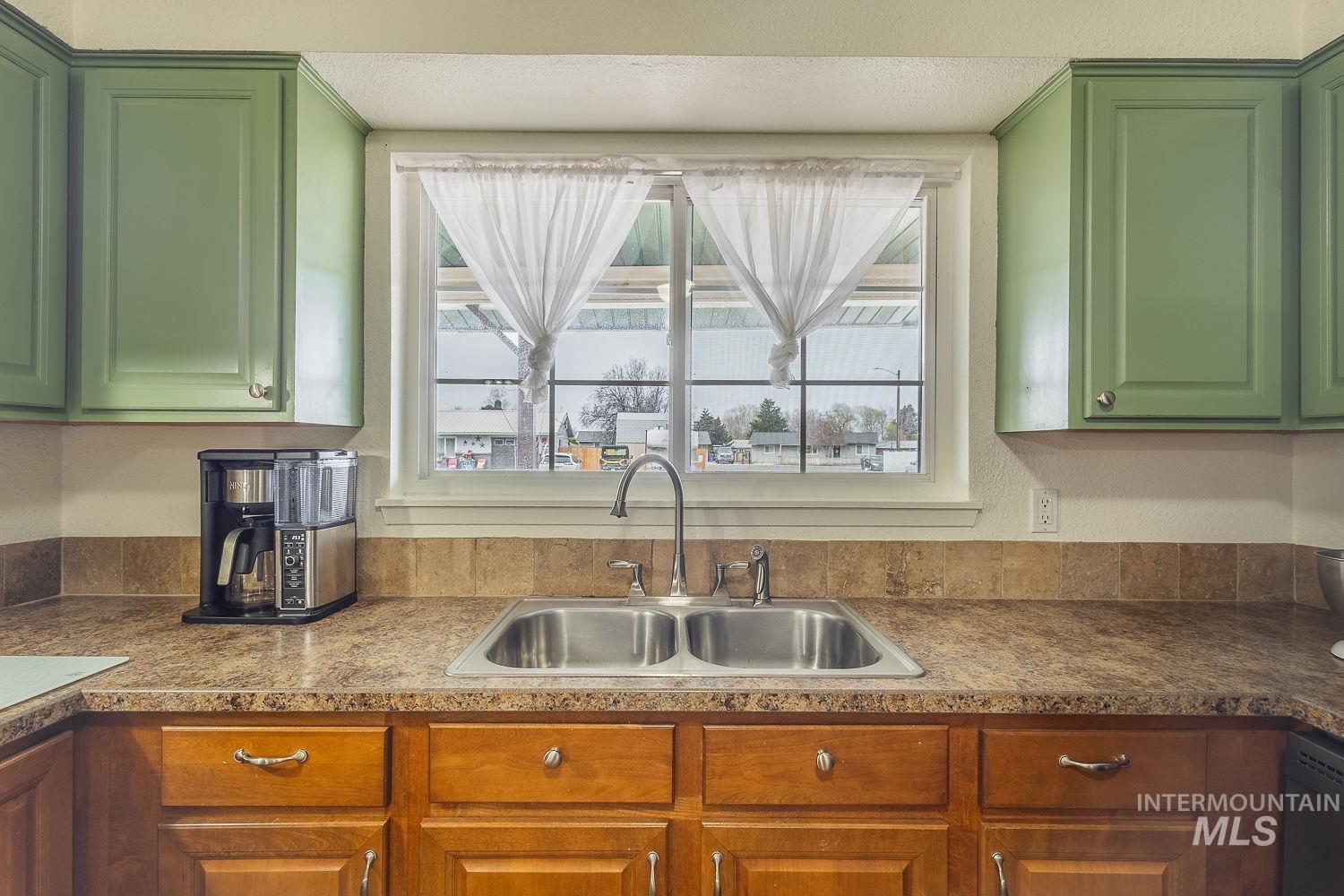 Kitchen featuring green cabinets, healthy amount of natural light, and dishwasher