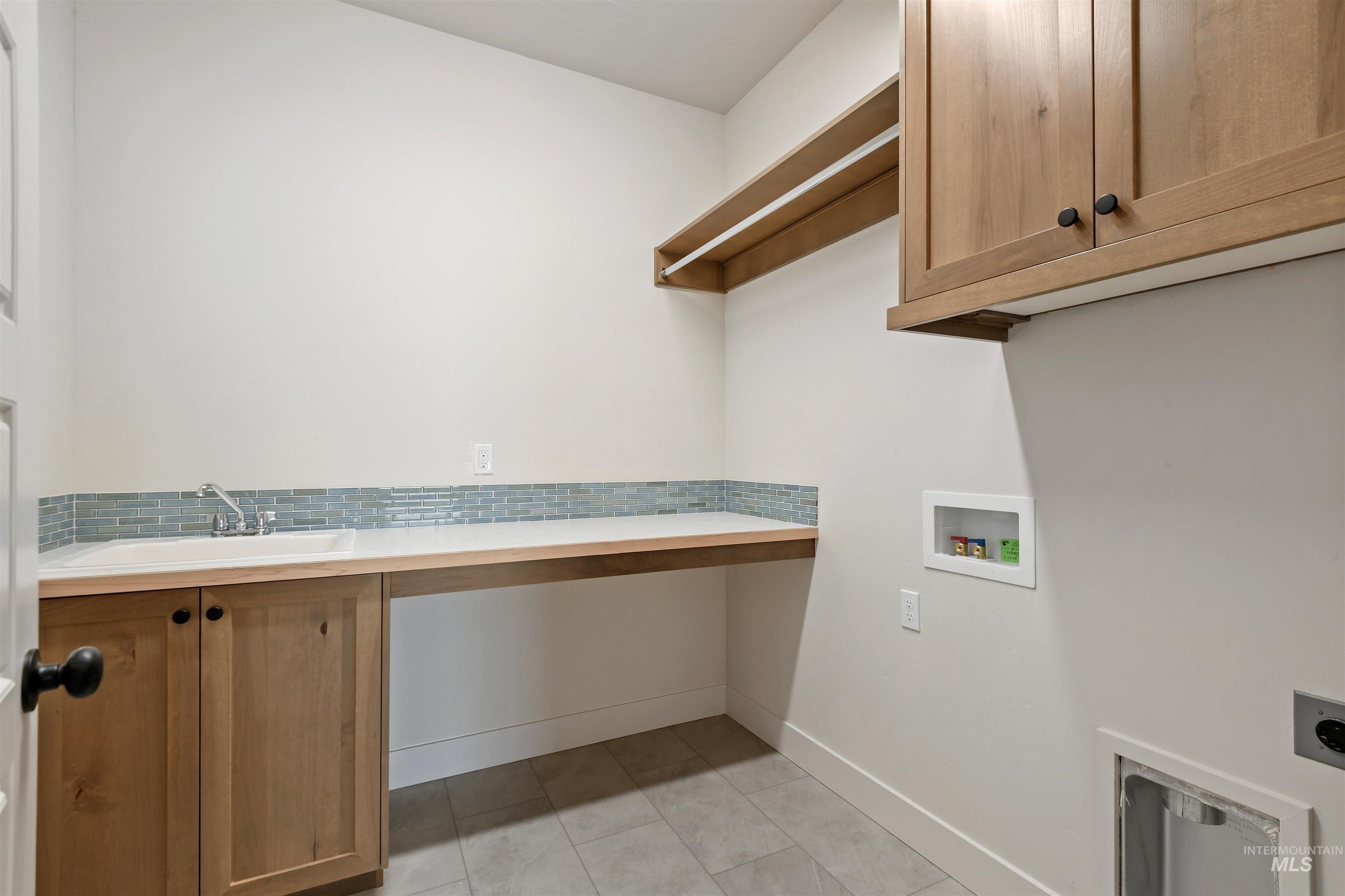 Laundry room featuring electric dryer hookup, cabinet space, and washer hookup