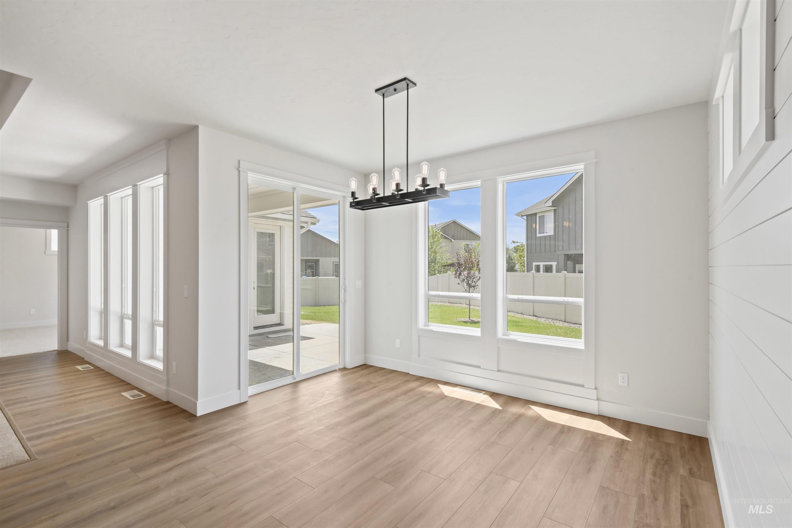 Unfurnished dining area with wood finished floors and a chandelier