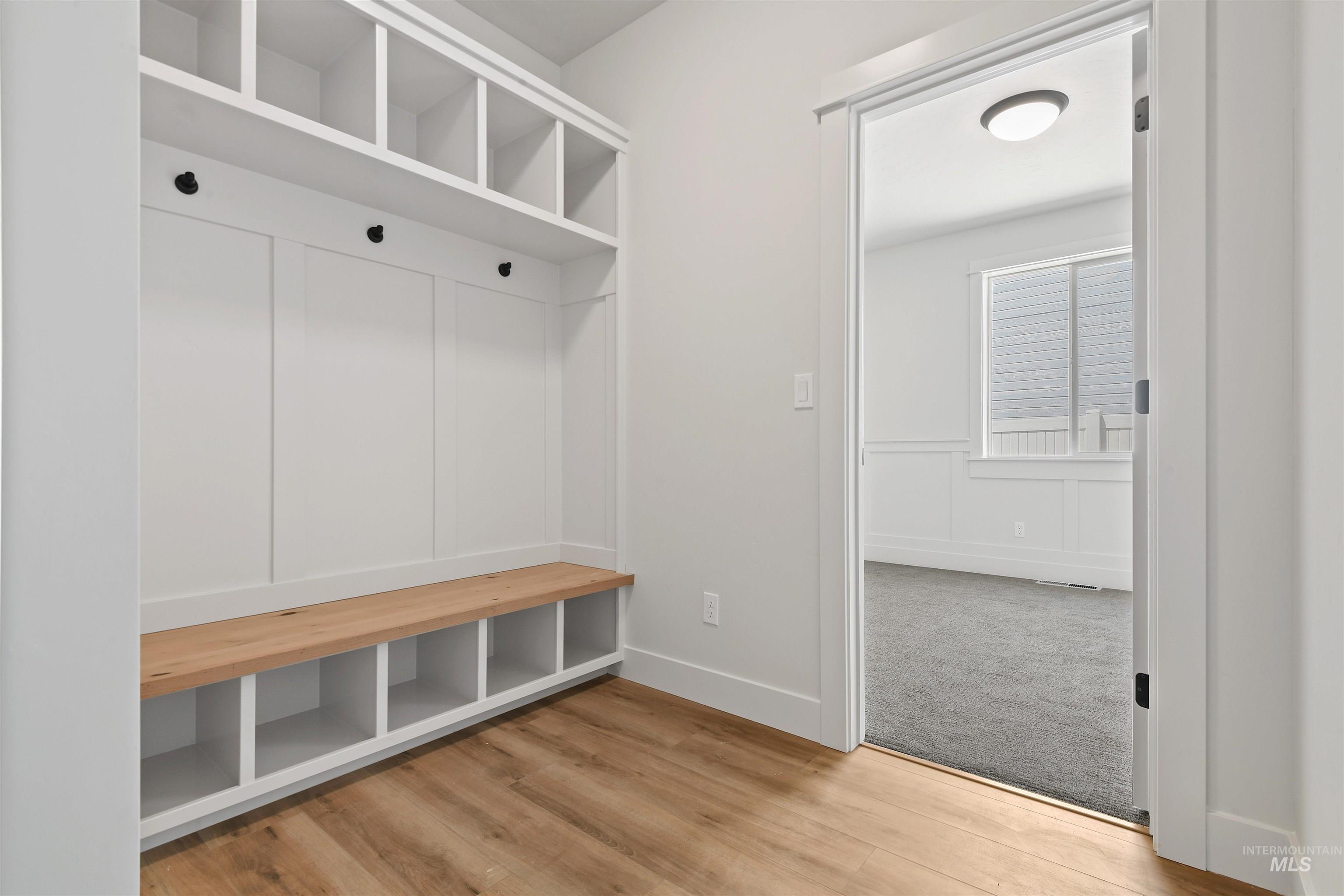 Mudroom with wood finished floors and baseboards