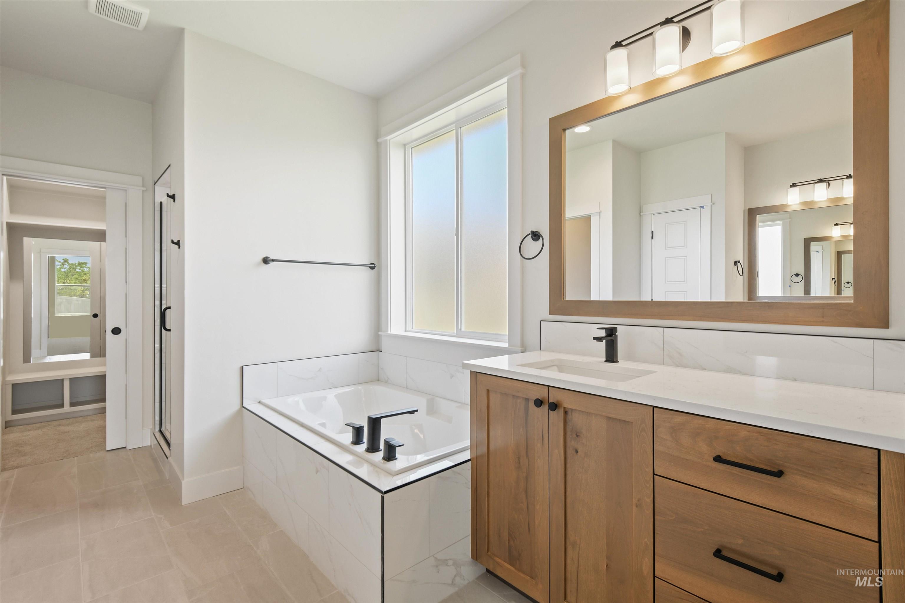 Full bath with vanity, a bath, tile patterned floors, and a stall shower