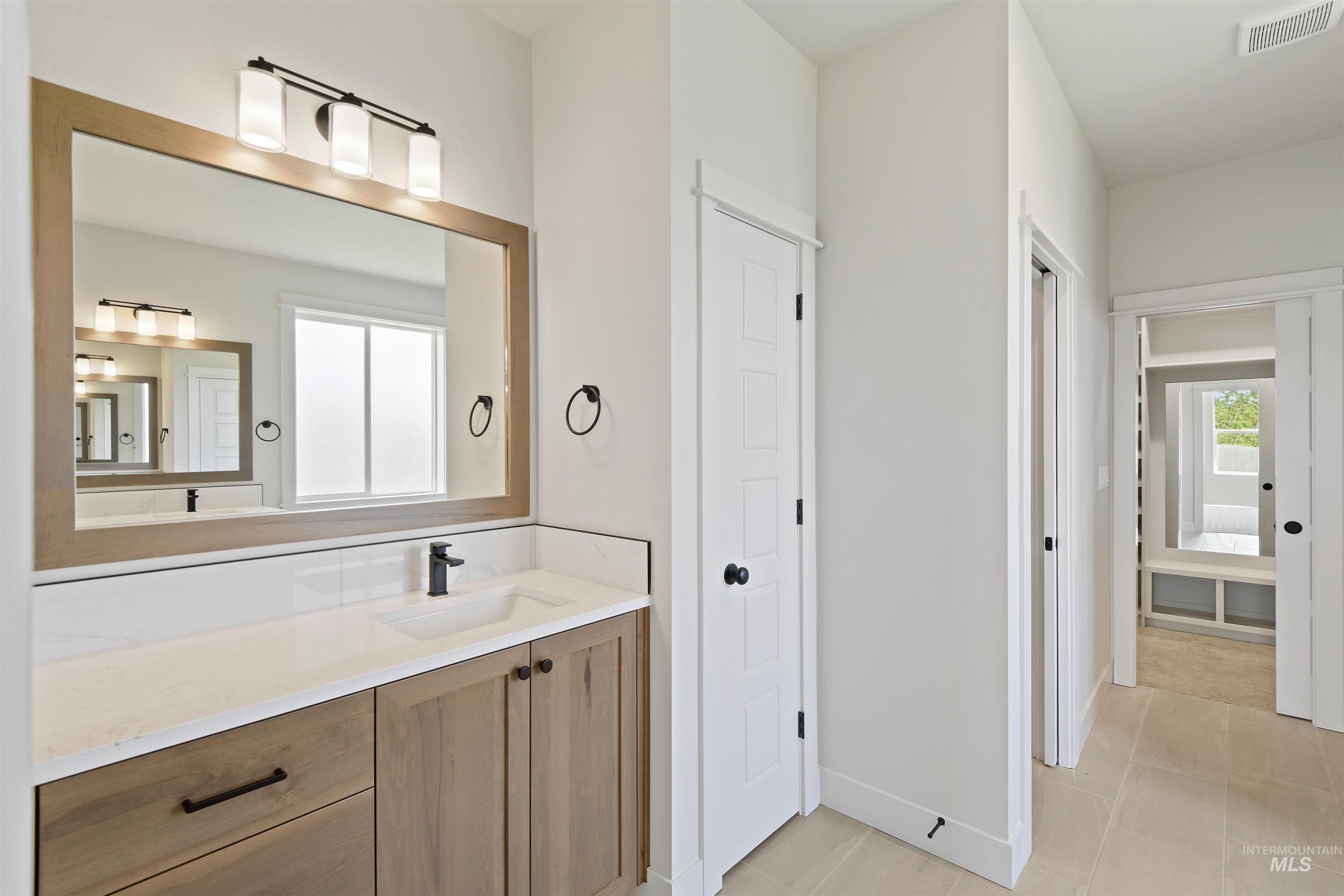 Bathroom featuring vanity, tile patterned flooring, and a closet