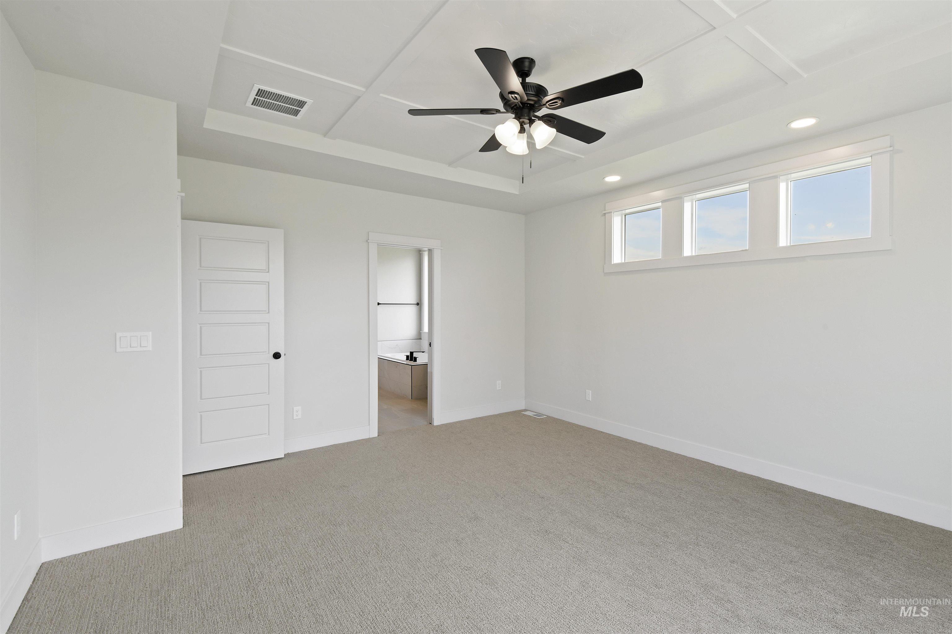 Unfurnished room with light colored carpet, a ceiling fan, recessed lighting, and a tray ceiling